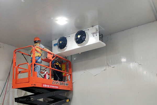 图为工人正在安装冷风机